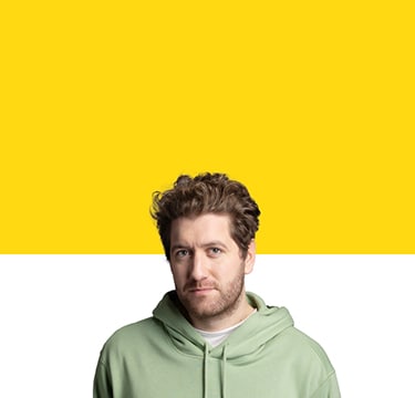 man in green sweatshirt in front of yellow background