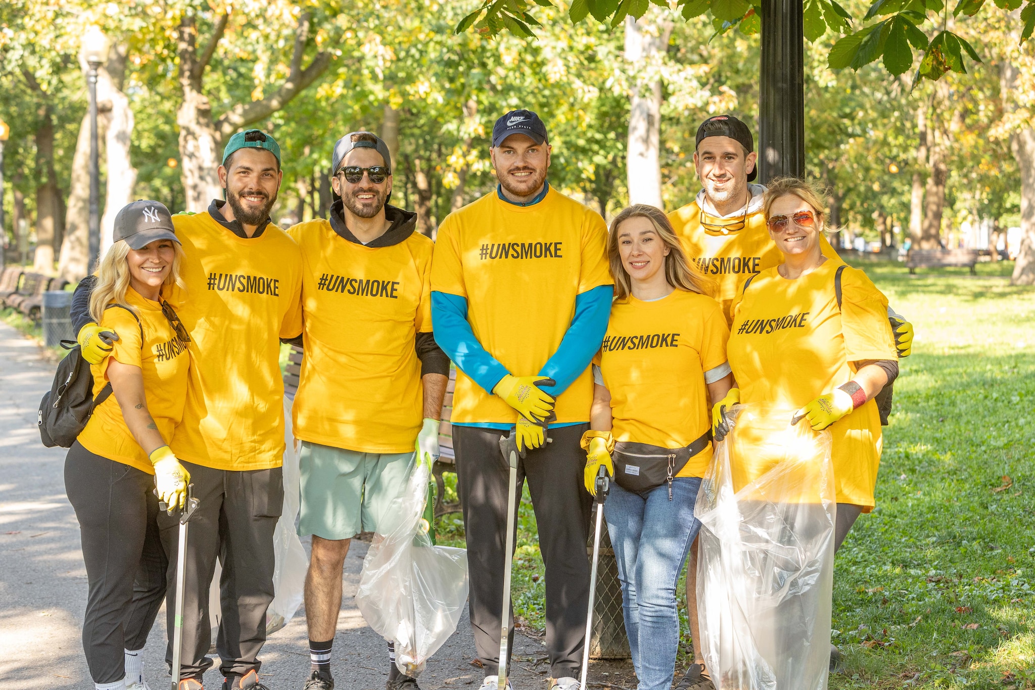 a group of volunteers wearing yellow unsmoke tee shirts posing for a picture