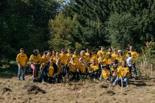 a group of volunteers wearing yellow unsmoke tee shirts posing for a picture